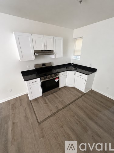 A kitchen with white cabinets and black countertops.