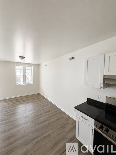 A kitchen with white cabinets and a black stove top.