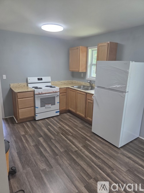 A kitchen with a white fridge, stove and oven.