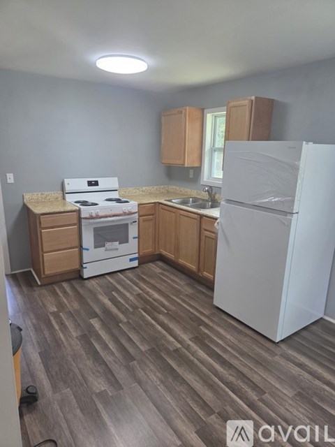 A kitchen with a white fridge, stove and oven.