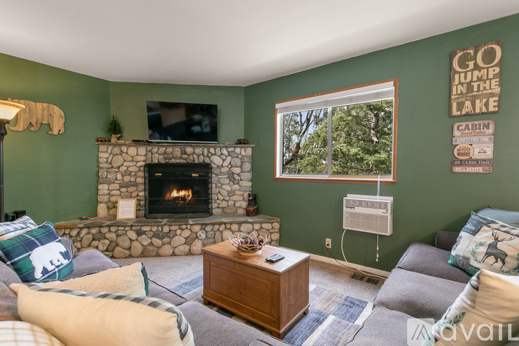 A living room with a fireplace and a flat screen TV mounted on the wall.