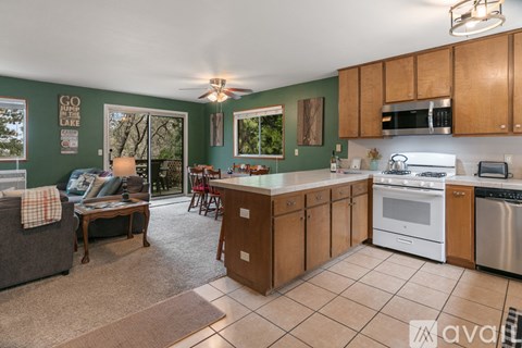 A kitchen with a white stove top oven and a white dishwasher.