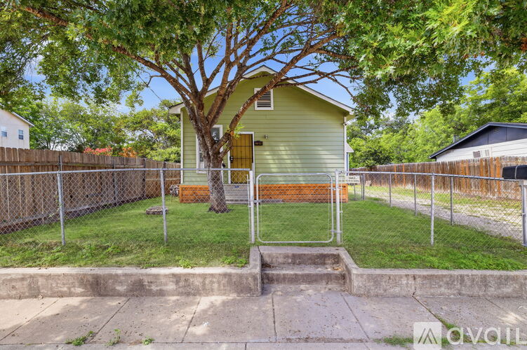 A yellow house with a tree in front of it.