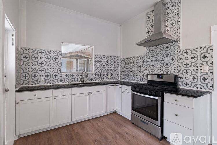 A kitchen with a black stove top oven and white cabinets.