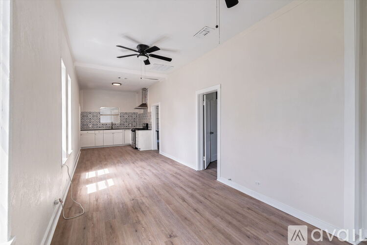 A room with a ceiling fan and wooden flooring.