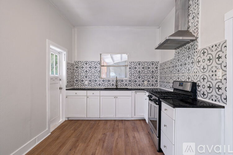 A kitchen with white cabinets and a black countertop.