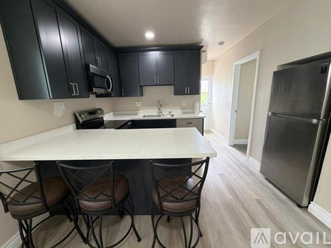 A kitchen with a table and chairs in the foreground and a refrigerator in the background.
