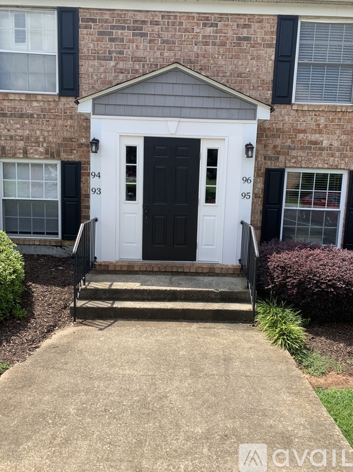 A house with a black front door and a white front door with a number 94 on it.