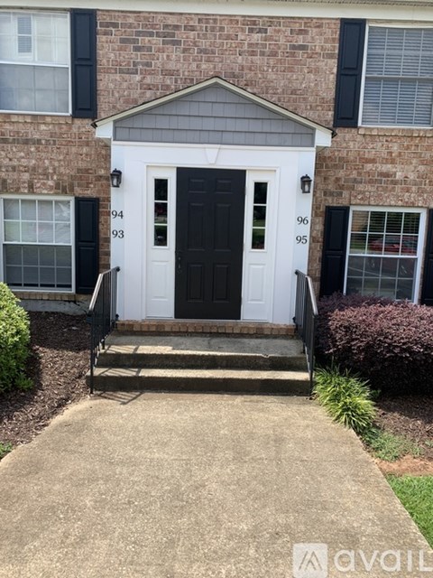 A house with a black front door and a white front door with a number 94 on it.