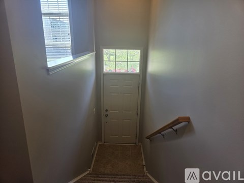 A hallway with a door and a window.