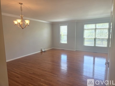 A room with wooden floors and a chandelier.