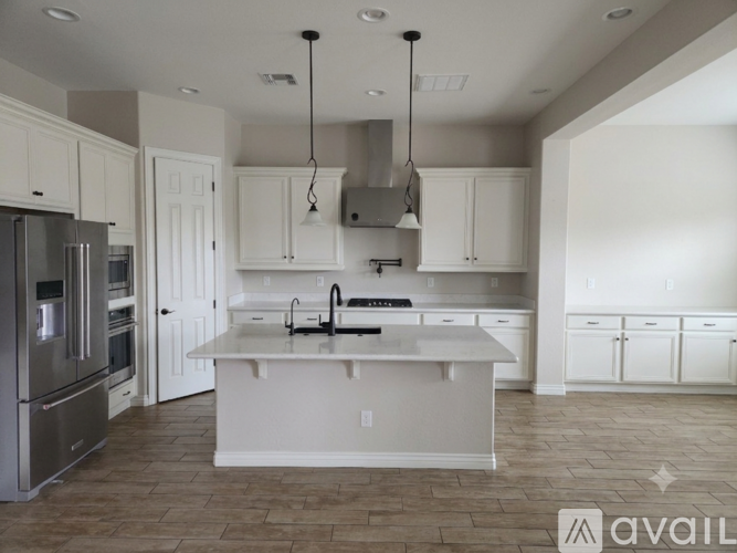 A modern kitchen with white cabinets and a central island.