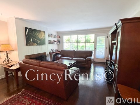 A living room with a brown leather couch and a painting on the wall.