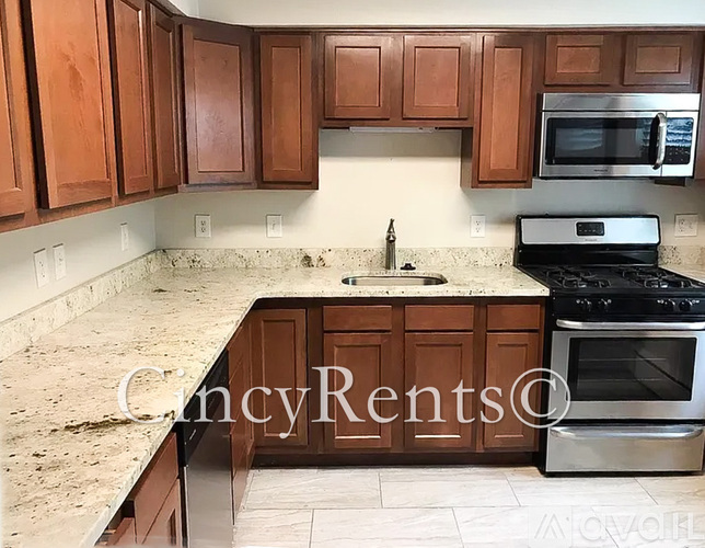 A kitchen with wooden cabinets and a granite countertop.