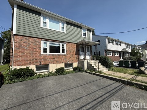 A house with a grey roof and a brick chimney is for sale.