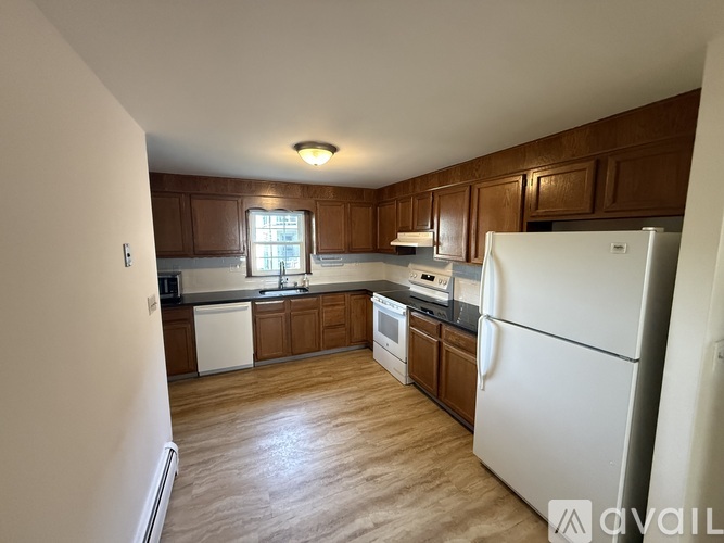 A kitchen with wooden cabinets and a white refrigerator.