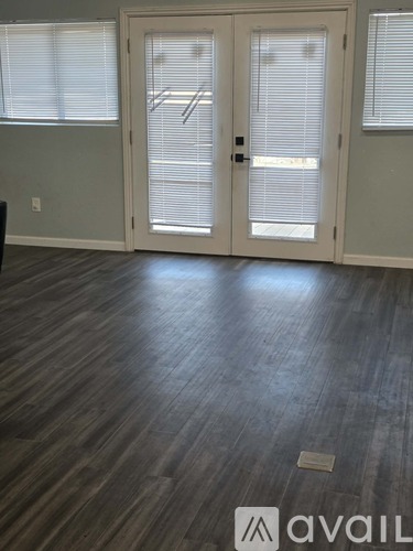 A room with a wooden floor and a white door.