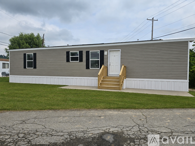 A mobile home with a brown front porch.