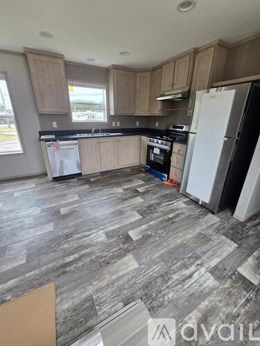 A kitchen with a black fridge and a black stove top oven.