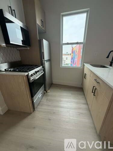 A kitchen with wooden cabinets and a window.
