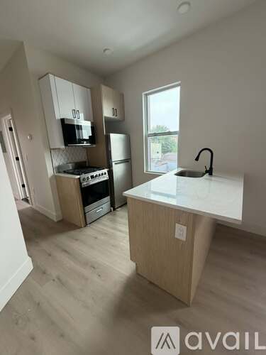 A kitchen with a white countertop and wooden cabinets.