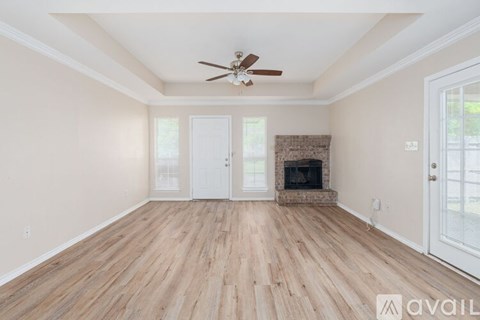 A room with a fireplace and a ceiling fan.