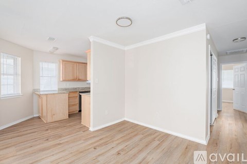 A kitchen with wooden floors and white walls is available for rent.
