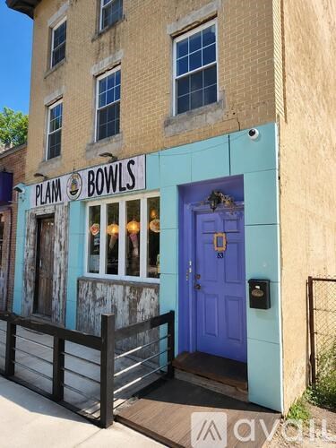 A building with a blue door and a sign that says "Plam Bowls".
