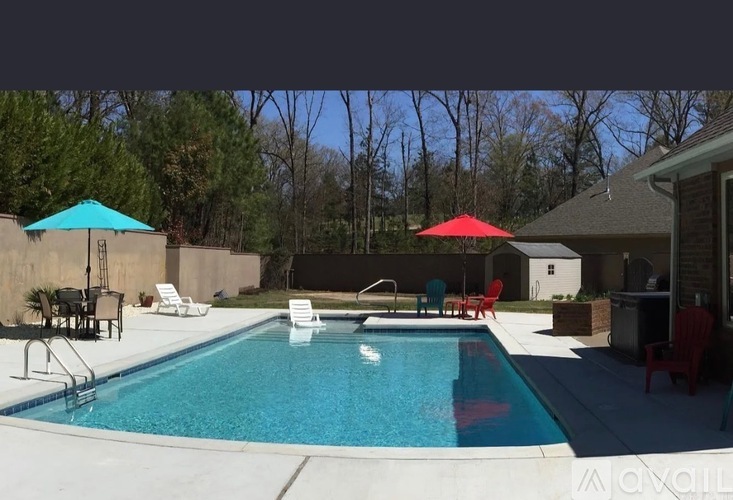 A pool with a blue umbrella and red umbrella.
