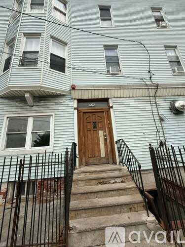 A building with a wooden door and a metal railing.