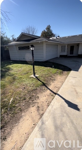 A house with a white garage door and a lamp post in front of it.