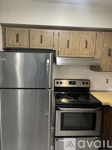 A kitchen with a stainless steel refrigerator and a stove top oven.