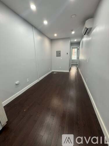 A long hallway with wooden floors and white walls.