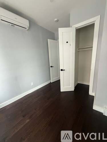 A room with a white door and a window with blinds.