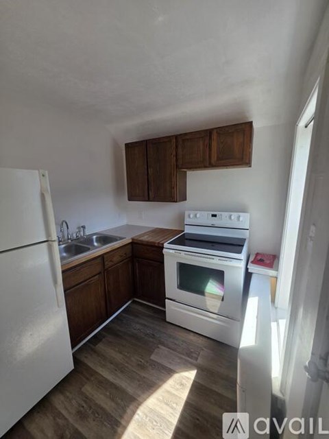 A kitchen with white appliances and wooden cabinets.