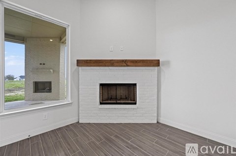 A modern living room with a fireplace and a large window.