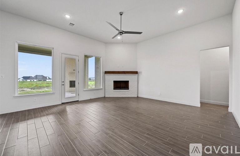 A spacious room with a fireplace and a ceiling fan.