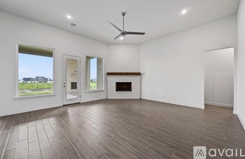 A spacious room with a fireplace and a ceiling fan.