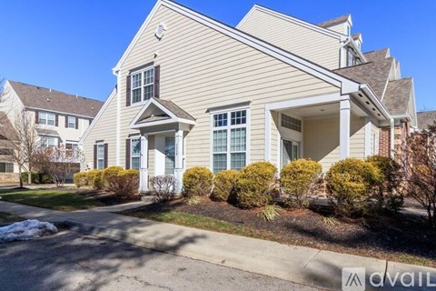A house with a well-maintained lawn and a clear sky.