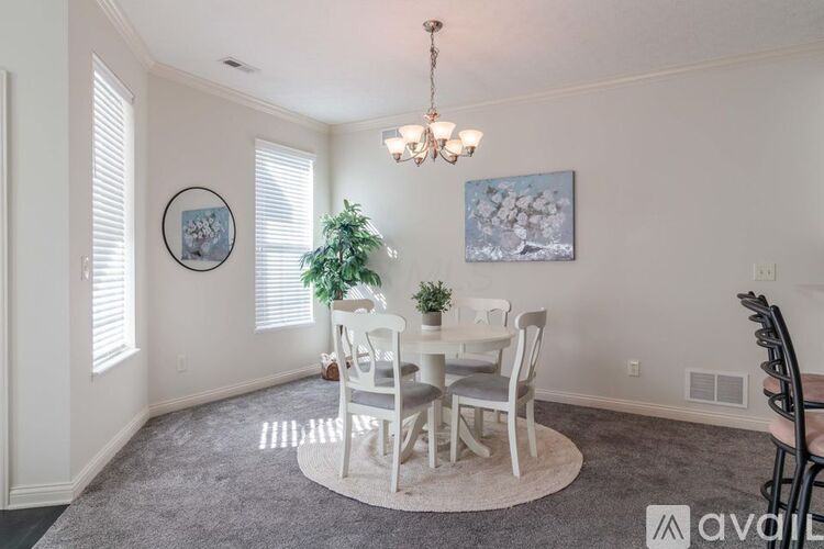A dining room with a white table and chairs.