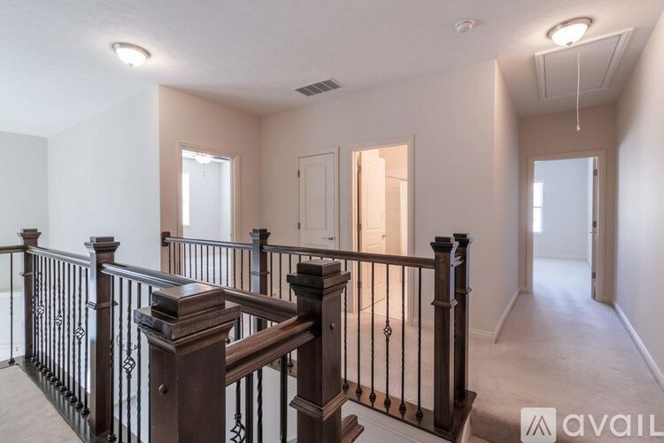 A spacious room with a staircase and a balcony.