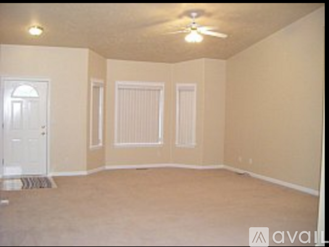 A room with a ceiling fan and three doors.