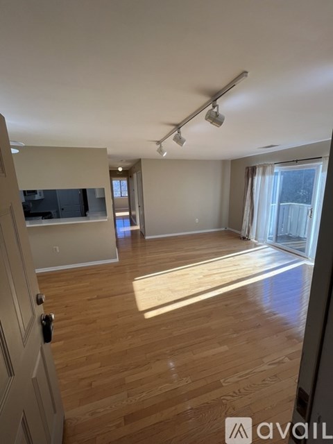 A room with wooden flooring and a sliding glass door.