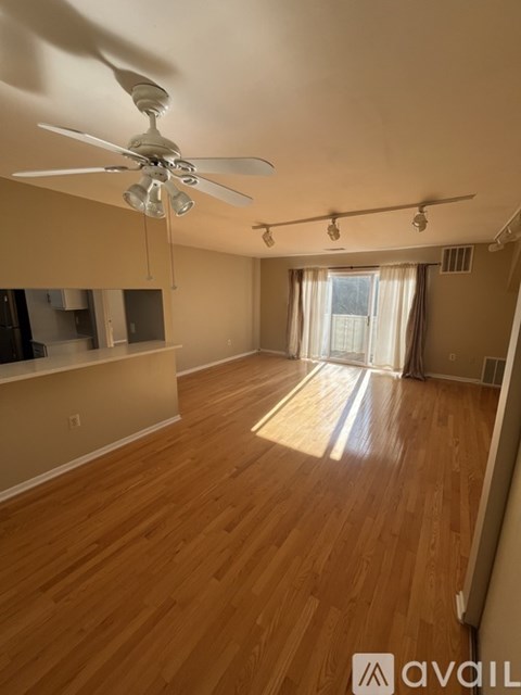 A room with wooden floors and a ceiling fan.