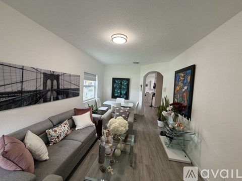 A living room with a grey sofa and a glass coffee table.