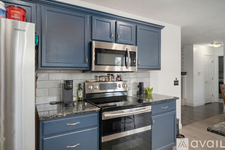 A kitchen with blue cabinets and stainless steel appliances.