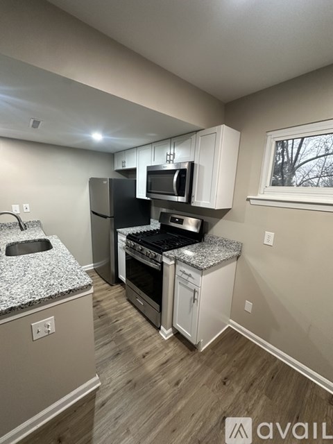 A kitchen with a black refrigerator, stove, and microwave.
