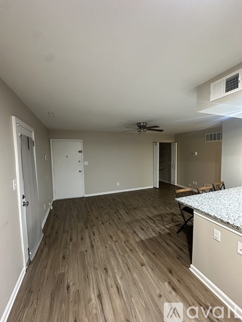 A room with wood flooring and a ceiling fan.