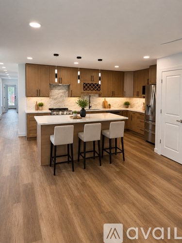 A modern kitchen with wooden floors and a central island.