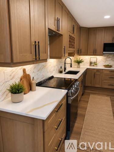 A kitchen with wooden cabinets and a marble backsplash.